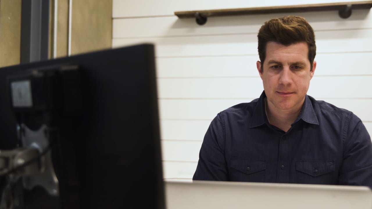 Shawn Livermore at a workstation reviewing application UI redesign work